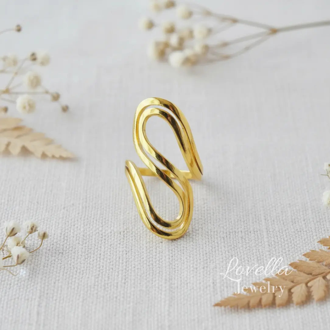 Gold ring on a light fabric background with dried flowers