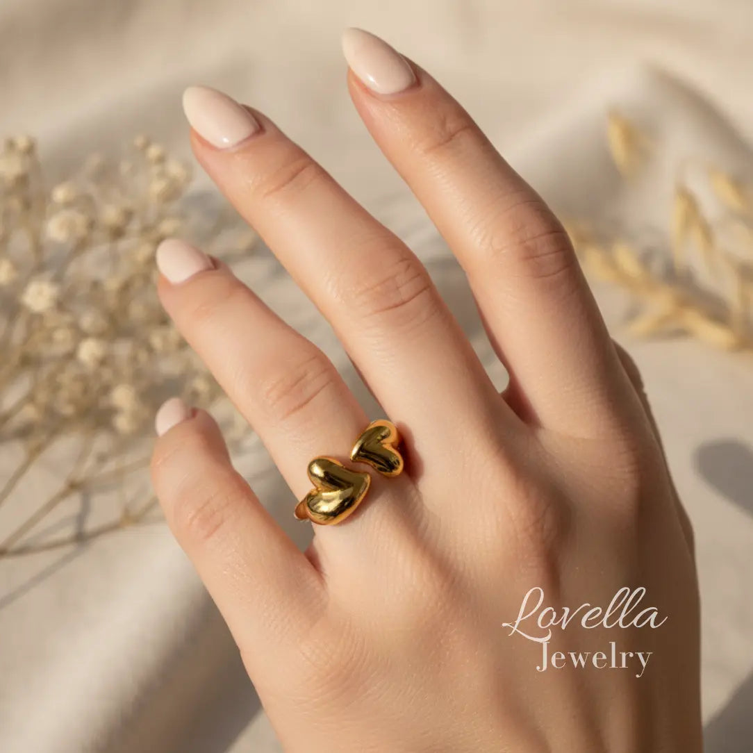 Gold heart-shaped ring on a hand with 'Lovella Jewelry' branding.