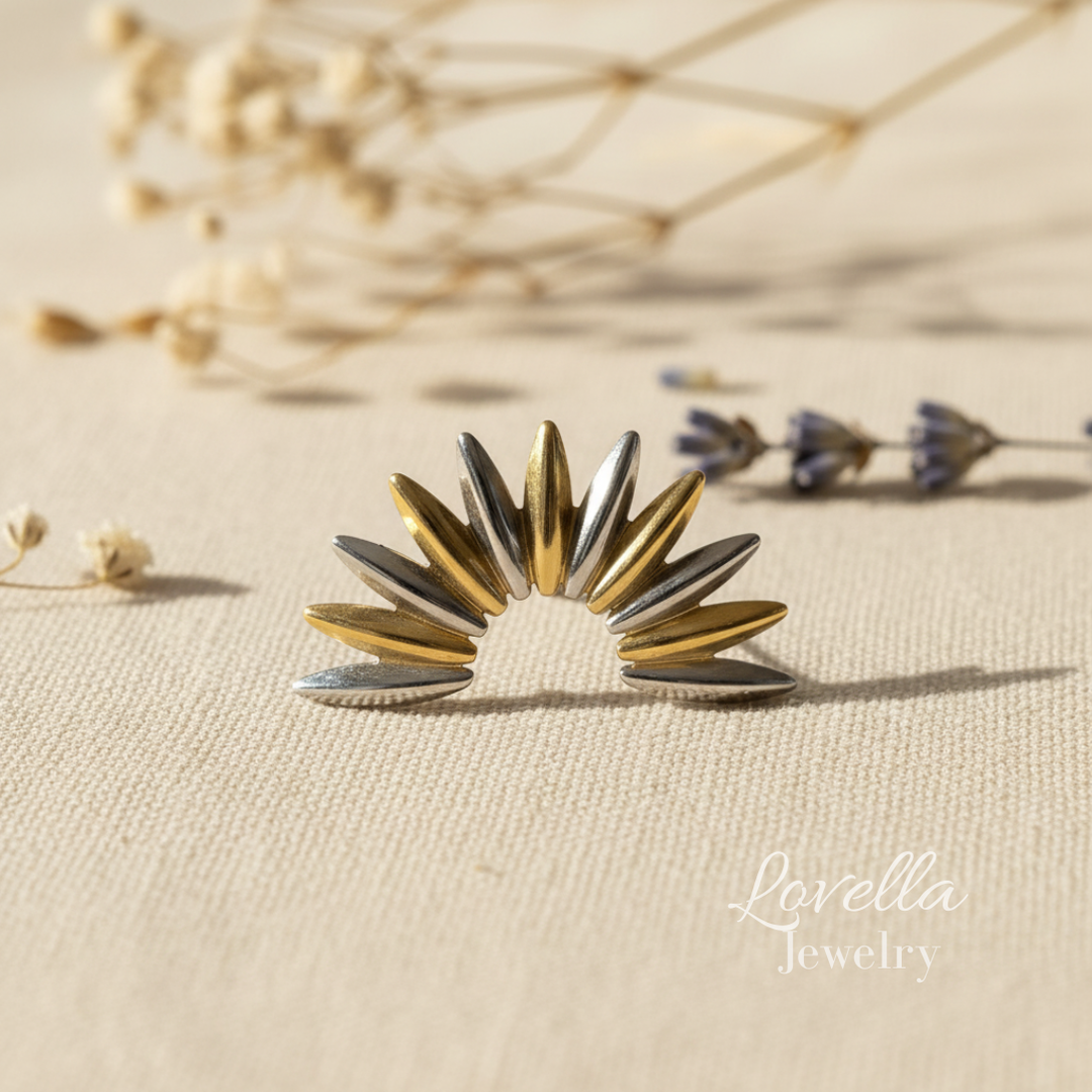 Gold and silver sunburst earring on a beige background with 'Lovella Jewelry' branding.