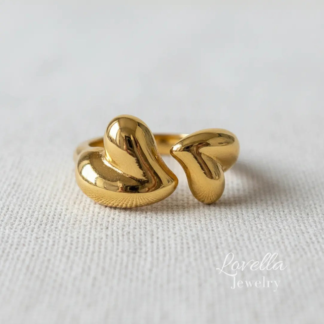 Gold ring with a unique design on a light fabric background, branded 'Lovellia Jewelry'.