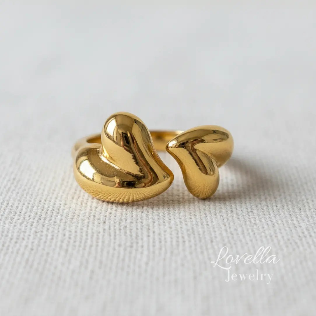 Gold ring with a unique design on a light fabric background, branded 'Lovellia Jewelry'.