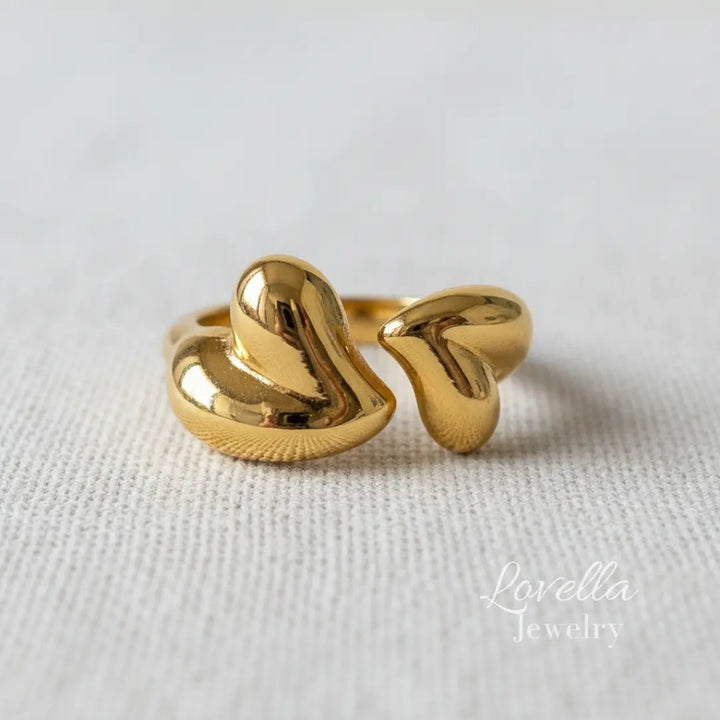 Gold ring with a unique design on a light fabric background, branded 'Lovellia Jewelry'.