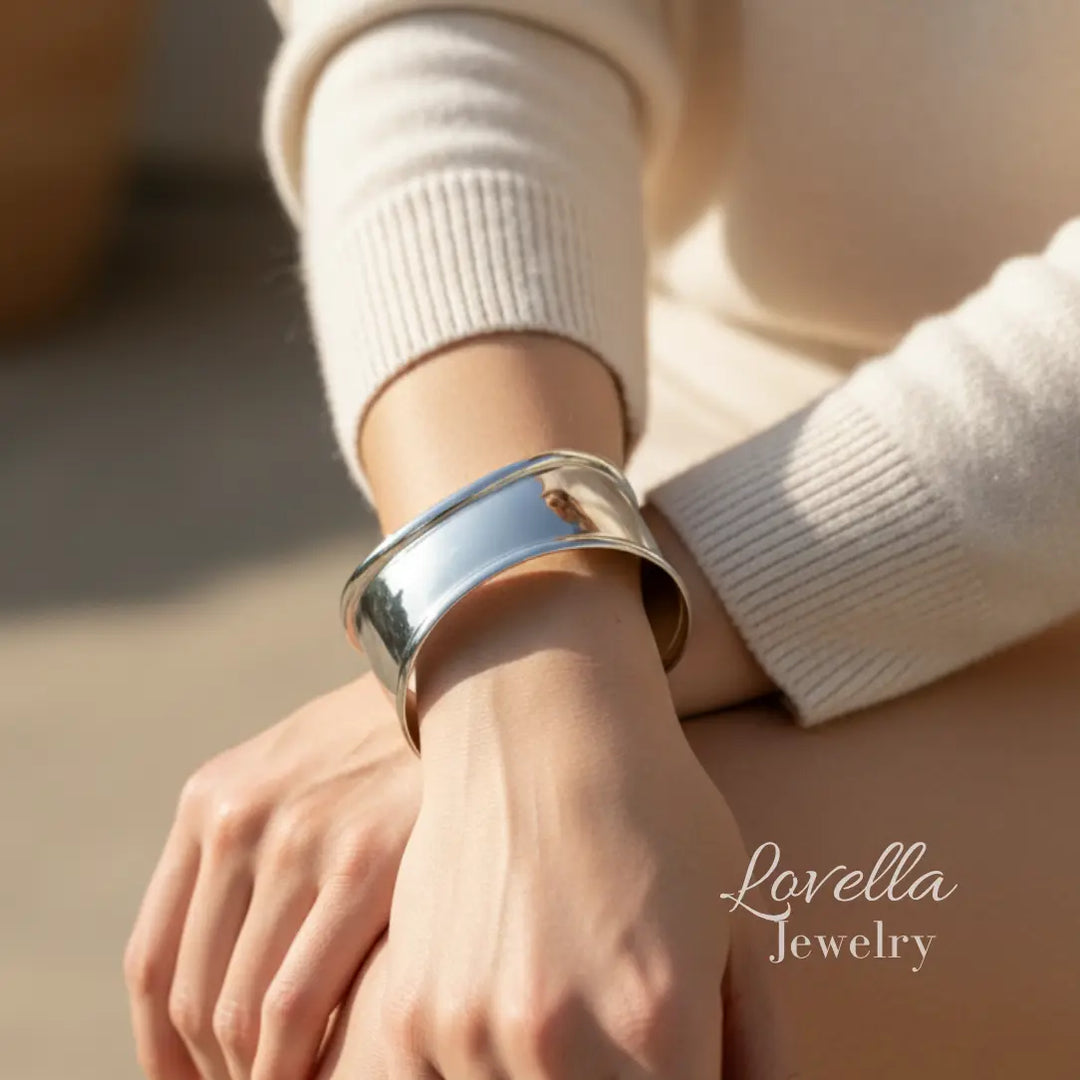 Silver bracelet on a wrist with 'Lovella Jewelry' branding.