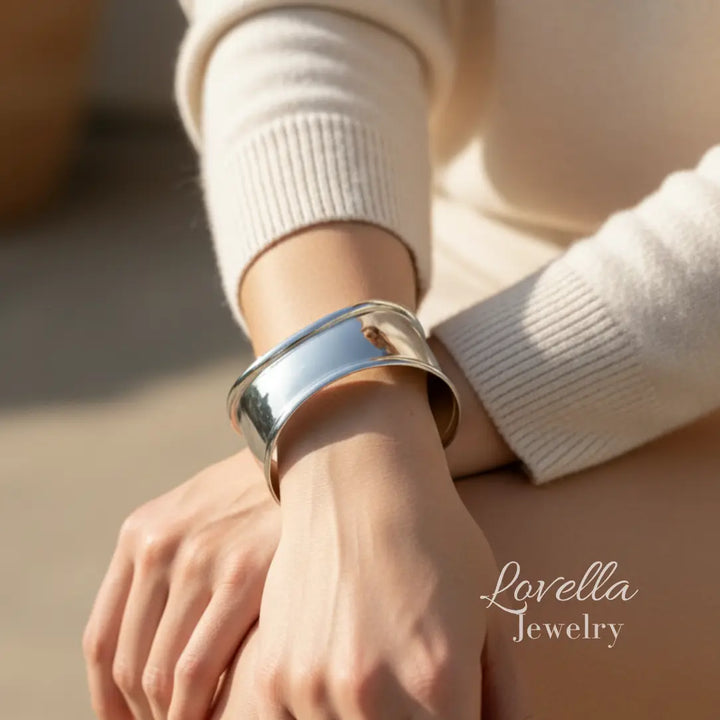 Silver bracelet on a wrist with 'Lovella Jewelry' branding.