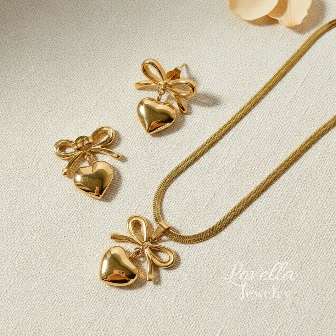 Gold heart-shaped jewelry set with bow details on a light background