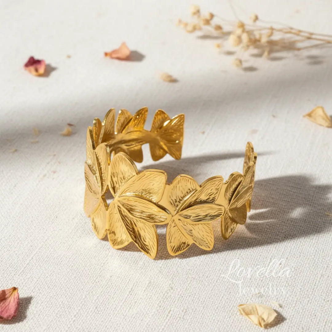 Gold leaf bracelet on a light background with dried flowers