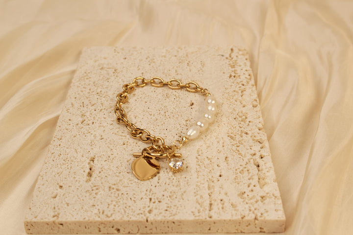 Elegante pulsera con dije de corazón de oro y perlas