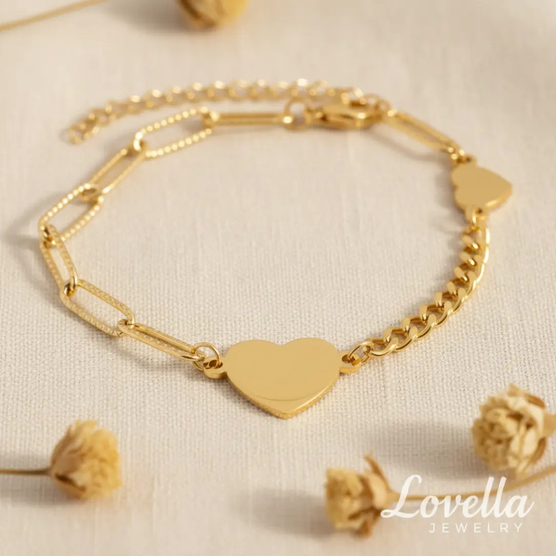 Gold bracelet with heart-shaped charm on a light background, featuring Lovella Jewelry branding.