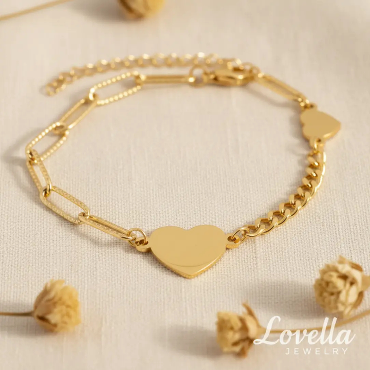 Gold bracelet with heart-shaped charm on a light background, featuring Lovella Jewelry branding.