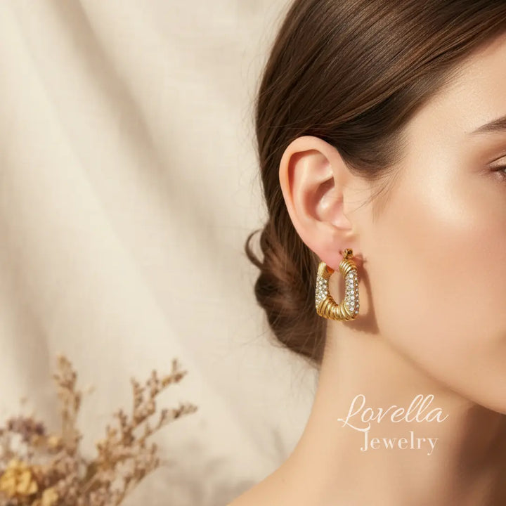 Gold hoop earrings worn by a model with 'Lovella Jewelry' branding.