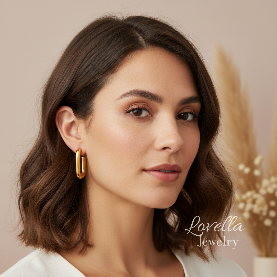 Woman wearing gold earrings with a blurred background and 'Lovella Jewelry' branding.