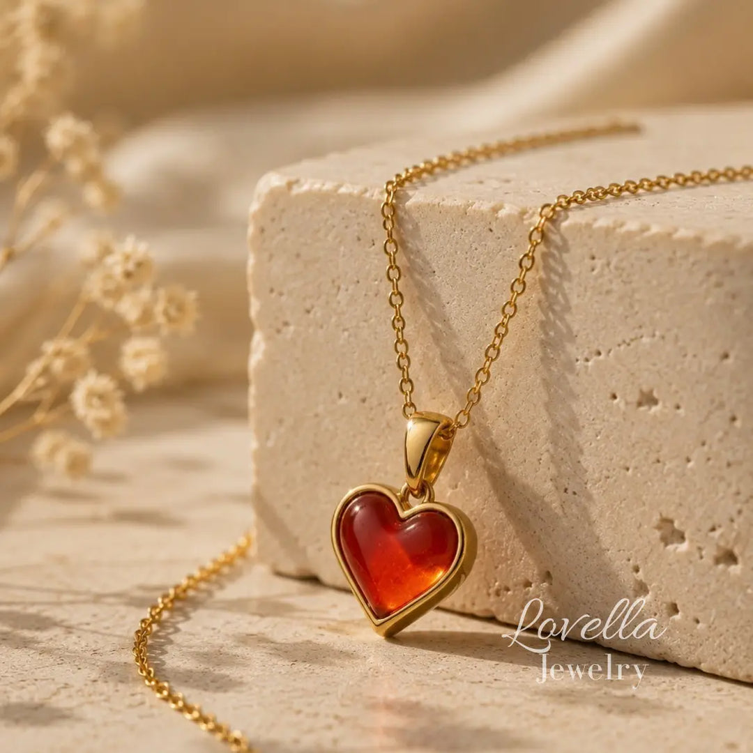 Amore Red Heart Necklace draped over cream stone with glossy red heart pendant in front