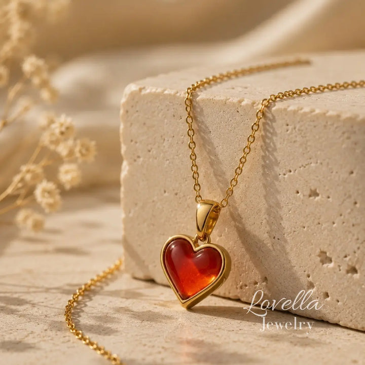 Amore Red Heart Necklace draped over cream stone with glossy red heart pendant in front