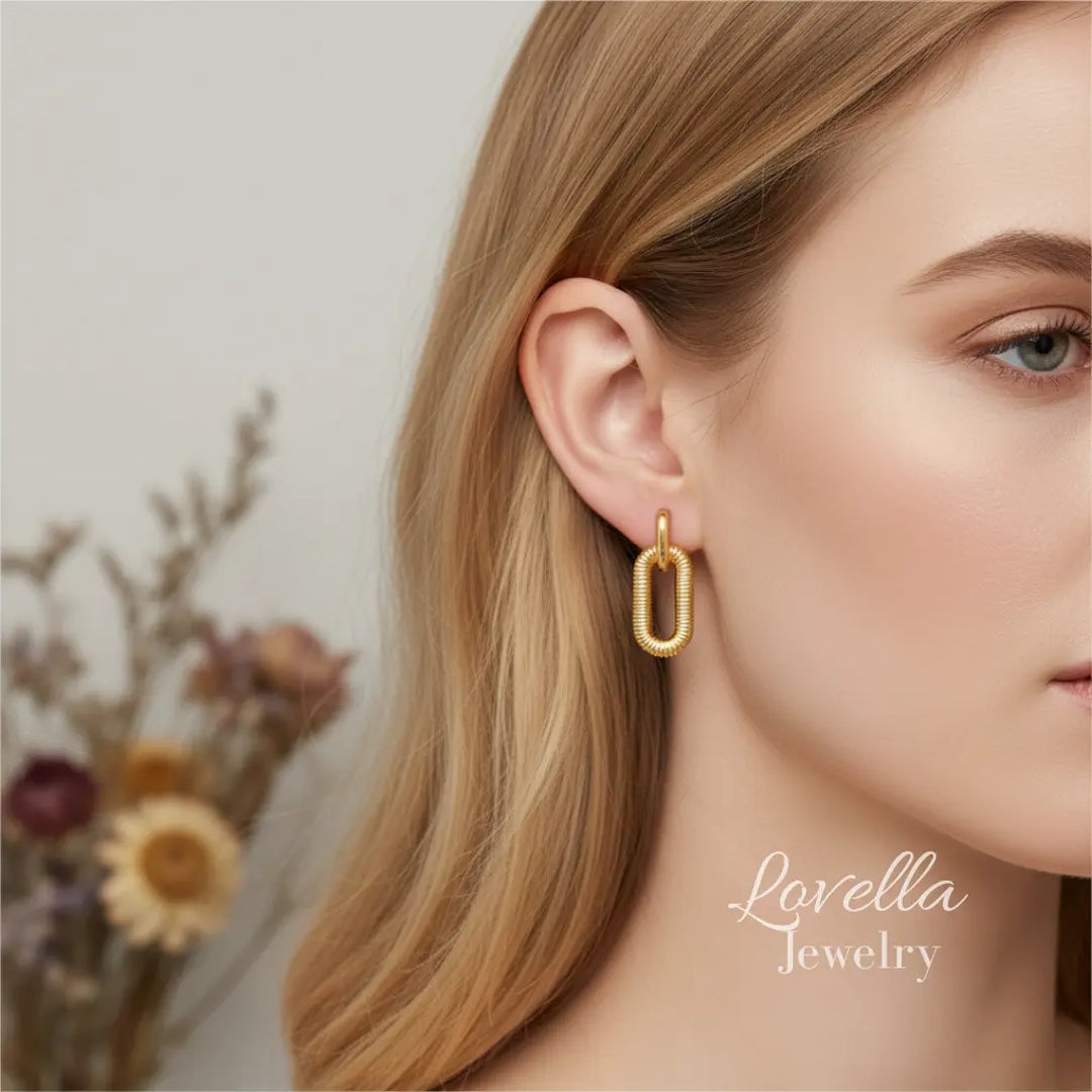 Gold earrings worn by a model with 'Lovella Jewelry' branding.