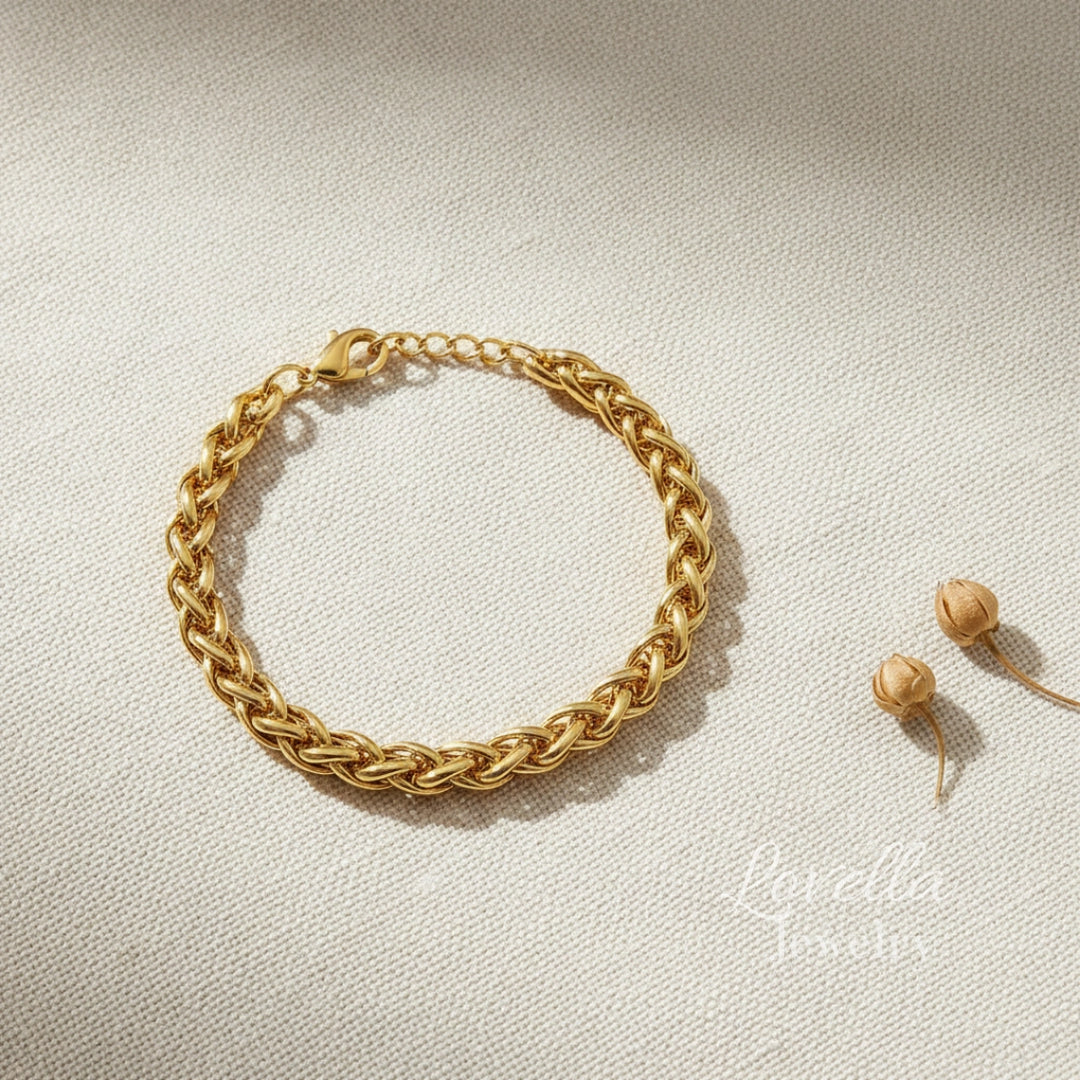 Gold chain bracelet on a light beige background