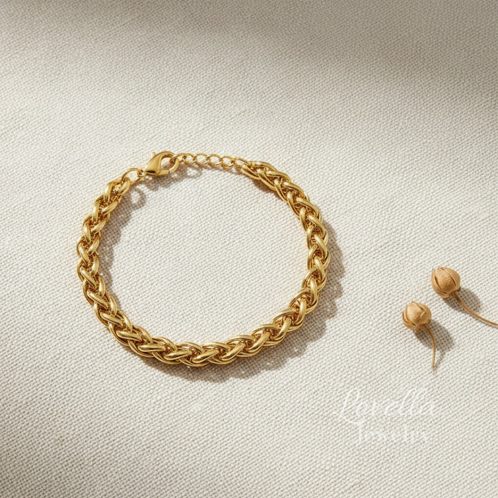 Gold chain bracelet on a light beige background