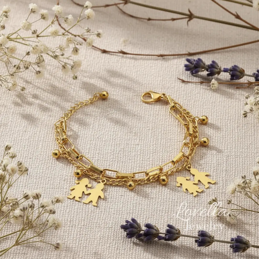 Gold bracelet with heart and person charms on a light background with flowers