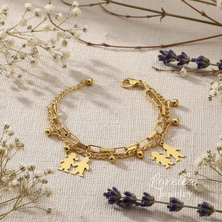 Gold bracelet with heart and person charms on a light background with flowers