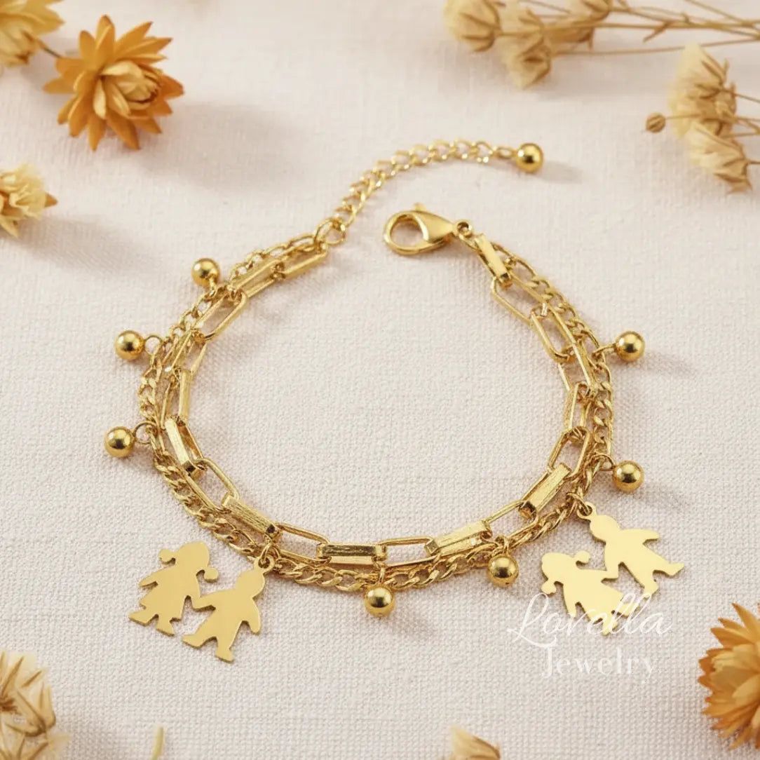 Gold bracelet with charms on a light background with dried flowers