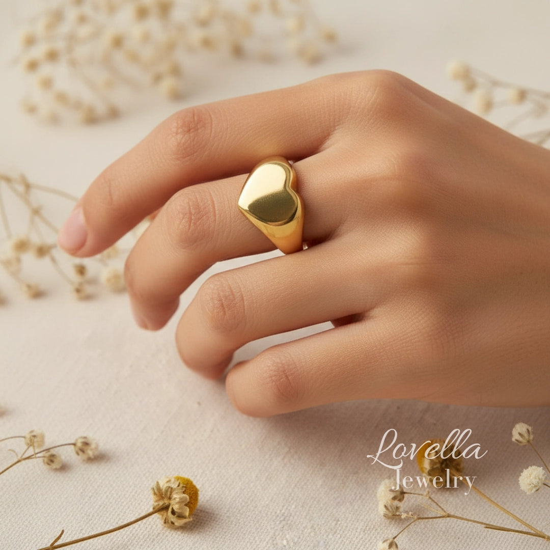 Gold ring on a hand with a soft background and 'Lovella Jewelry' branding.