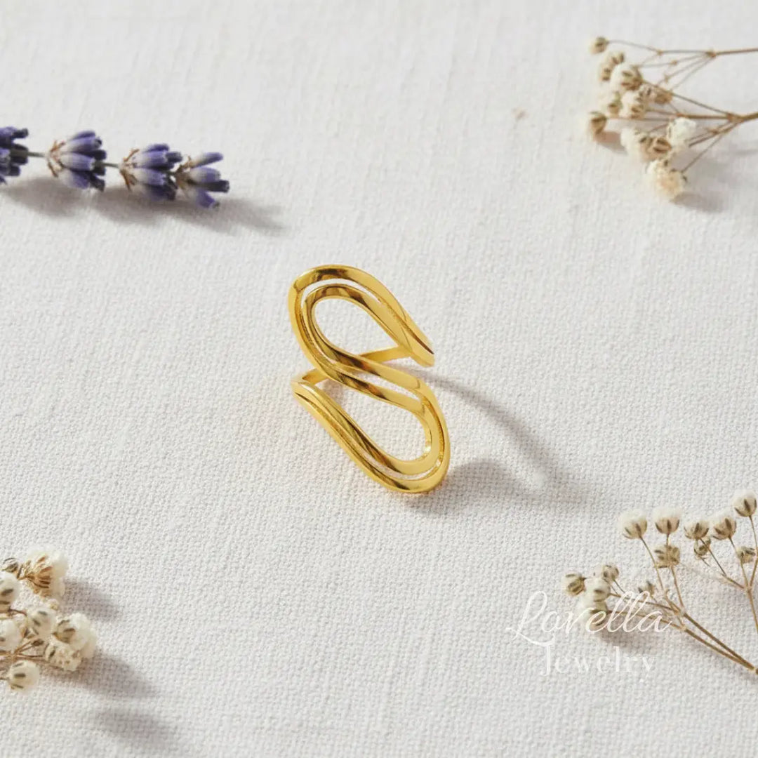 Gold ring on a light fabric background with dried flowers