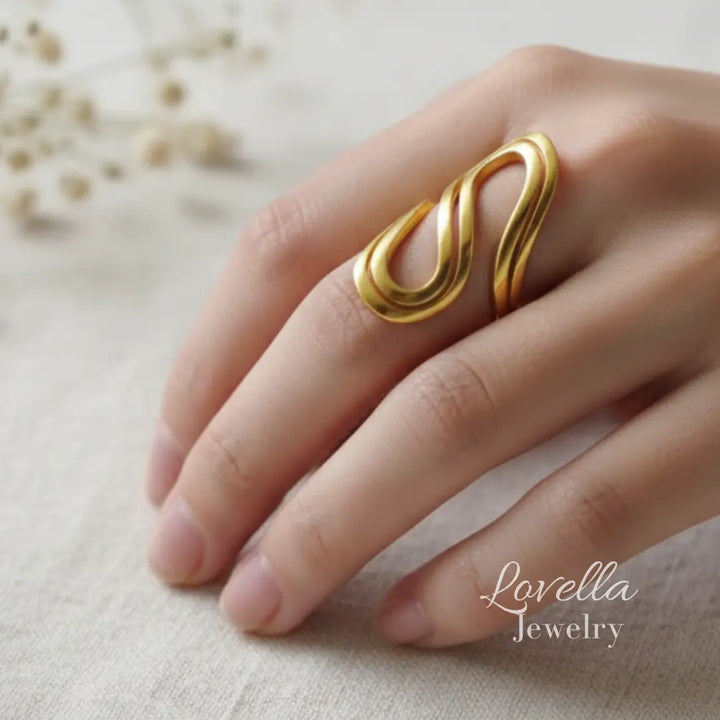 Gold ring on a hand with 'Lovella Jewelry' branding